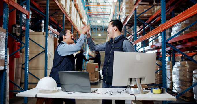 Logistics, computer or team with high five in warehouse for shipping target, sales record or good news. Distribution manager, excited people and tech with celebration for supply chain deal and profit