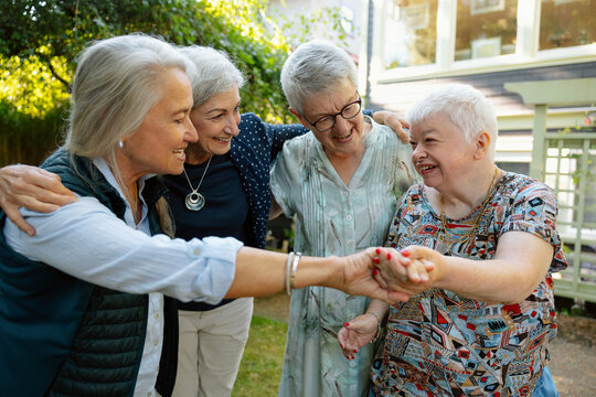 Friends and family share a moment holding hands outdoors