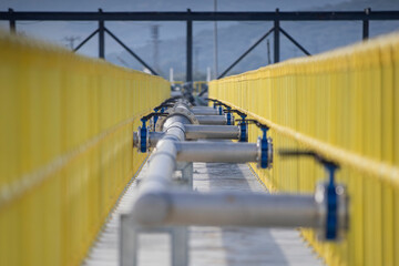Industrial Pipeline Infrastructure with Yellow Safety Railings – Modern Engineering and Water Management System
