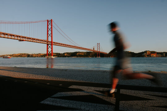 Runner passing by the 25 de Abril Bridge in Lisbon