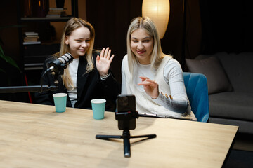 Two Content Creators Waving at Camera During Live Podcast Recording
