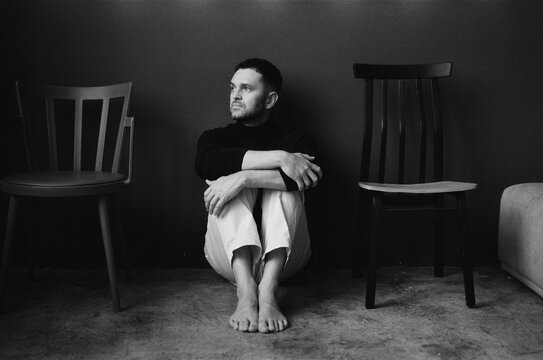 Man between chairs in minimal space