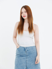 Studio portrait of asian attractive beautiful young woman in white tank top, denim skirt, posing smile on white background, minimal fashion style casual outfit lifestyle clothing advertising concept.
