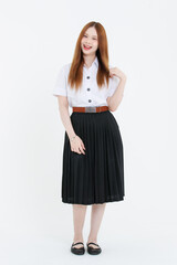 Fototapeta premium Studio portrait of asian cheerful beautiful happy young woman wearing white blouse, black pleated skirt, black flats posing on white background, university student uniform, education lifestyle concept