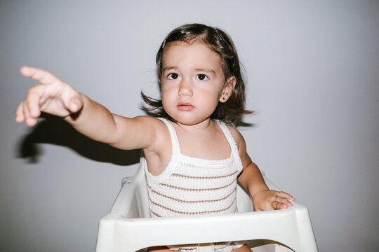 Toddler girl finger pointing, expressing curiosity