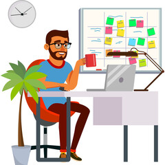 Smiling Business Man Sitting at Desk Working on Laptop Holding Coffee Cup with Plant and Whiteboard in Background and Office Clock on Wall