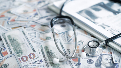 Pills and medical equipment placed on US dollars symbolizing rising pharmaceutical prices, expensive medicine and healthcare cost concerns.