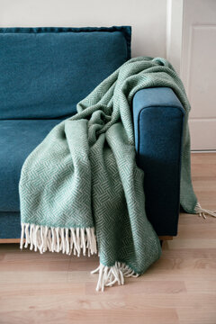 Comfy wool blanket on a blue couch