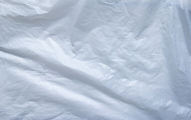 Close up of white plastic surface with natural folds and soft reflections. Ideal as texture background for design, packaging mockup, or minimalist visuals.