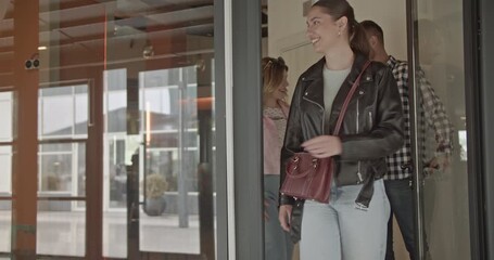 Professional colleagues entering a contemporary office building, ready for a productive workday.