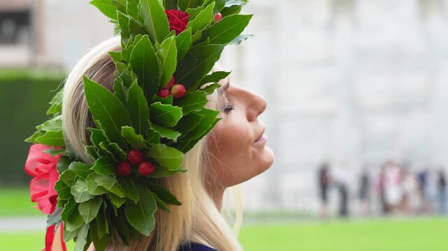 Young woman graduate wearing a laurel wreath celebrates graduation in Pisa&rsquo;s Piazza dei Miracoli