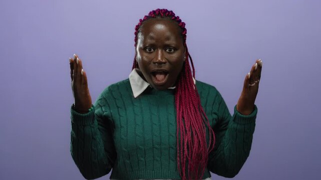 Woman with braided hair energetically uncovers her eyes against a purple background conveying surprise emotion
