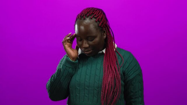 Woman with red braids in green sweater stands over isolated pink background in thoughtful pose expressing emotion.