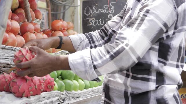 Hand reaching for fresh fruits in vibrant market scene