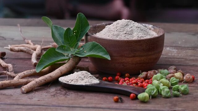 Ashwagandha Roots and powder known as Withania somnifera in white bowl on wooden background. Indian ginseng, poison gooseberry, or winter cherry. Herbal adaptogen ayurvedic medicine.