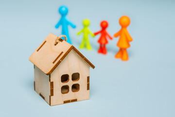 Multicolored figures of little men, a family on an isolated blue background, in the foreground a...