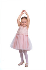 Rear view of a little girl in a pink tutu and ballet slippers, standing gracefully with a tiara on her head, holding pointe shoes.Little ballerina practicing dance moves. 