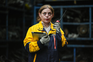 Female hispanic technician inspect used car damaged part at scrap yard warehouse recycle area....