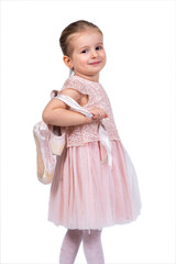 Rear view of a little girl in a pink tutu and ballet slippers, standing gracefully with a tiara on her head, holding pointe shoes.Little ballerina practicing dance moves. 