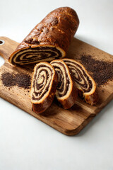 Delicious swirled chocolate nut roll cake sliced on a wooden board