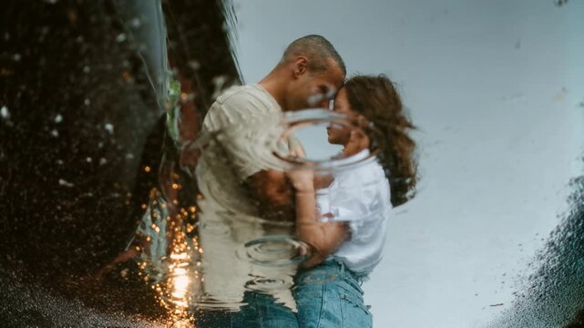 Tender couple embraces in the rain, cinematic droplets and soft backlight highlight romance, resilience and a second‑chance love story&mdash;emotional, relatable and perfect for campaigns about connection.