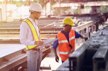 Young engineer is inspecting the work in the factory, the work of the plasterers on the construction site and the work of pouring cement.