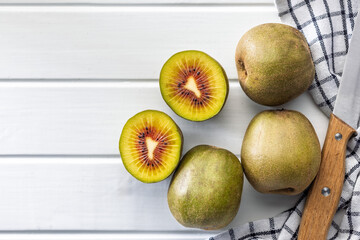 Red kiwi fruit on white table. Top view.