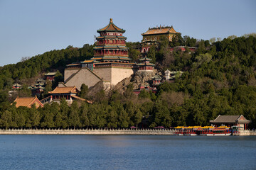 Tower of Buddhist Incense towering above palace complex and waterfront promenade with tourist facilities, Summer Palace Beijing, elevated landscape view, horizontal composition