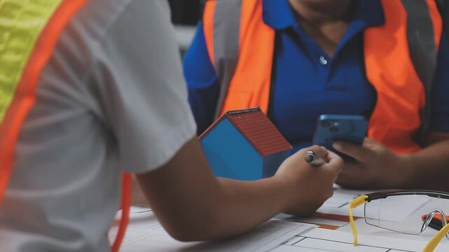 team of multiethnic architects working on construction plans in meeting room engineers discussing on project in office mature businessman and woman standing around table working on blueprint no logos