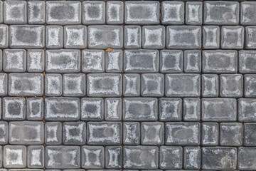 Gray brick wall with a few brown leaves on it