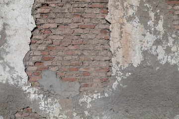 Brick wall with a hole in it. The wall is made of bricks and has a white base