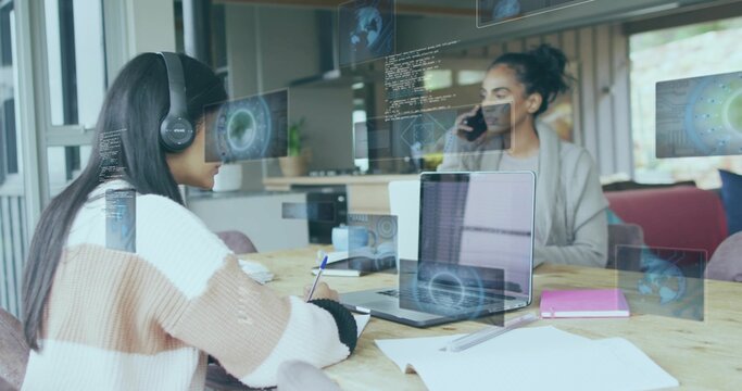 Collaborating teen and mentor viewing code overlays at open workspace, with laptop and smartphone
