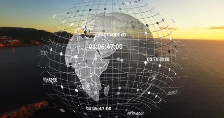 Obraz premium Displaying digital wireframe globe with grid lines and numeric labels over coastal sunset seascape