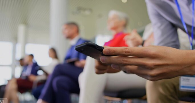 Showing businesswoman holding black smartphone at chest height in conference room, copy space - Powered by Adobe