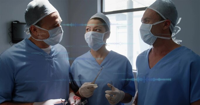 Holding forceps and retractors, surgical team in blue scrubs preparing procedure in hospital OR