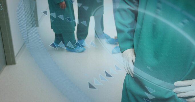 Standing male surgeon wearing green scrubs in hospital corridor, with digital overlay, copy space - Powered by Adobe