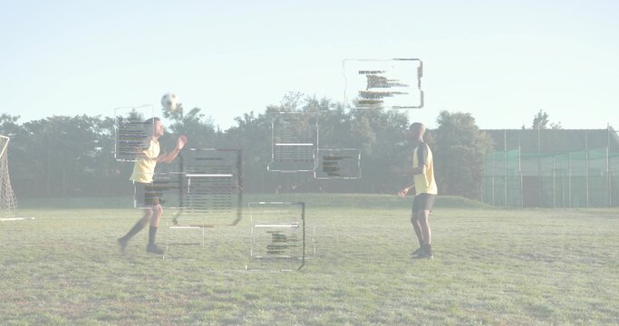 Male soccer player wearing yellow jersey heading soccer ball on grassy field, with digital overlays