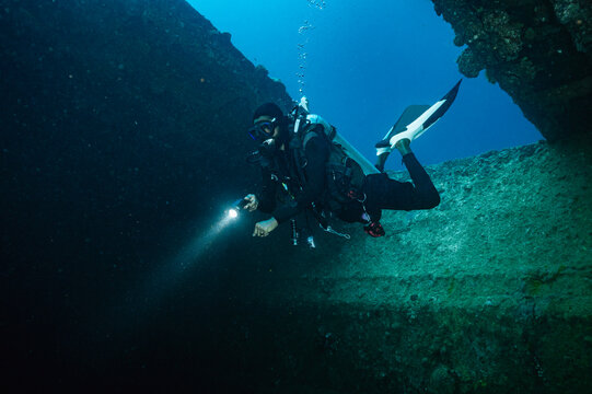 local dive master exploring wreck in the Maldives
