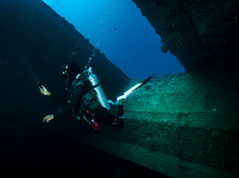 local dive master exploring wreck in the Maldives