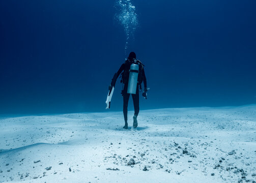 dive master walking on a sand bank underwater in the Maldives
