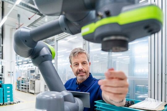 Engineer operating industrial robot in an automated factory setting