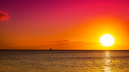 A breathtaking sunset or sunrise illuminates the ocean horizon and serene seascape