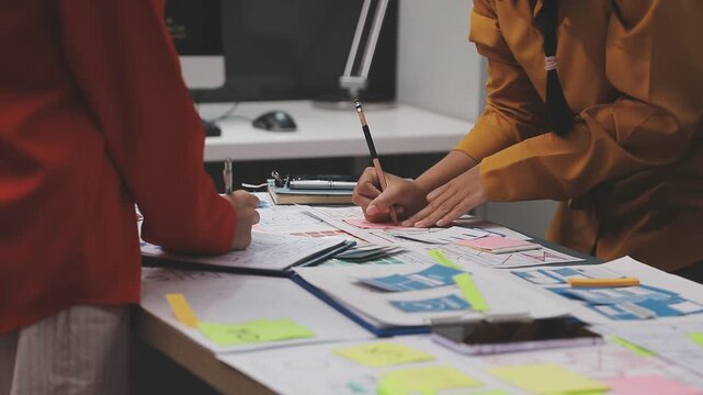 Group of young application developers analyzing uxui mobile app templates during a working meeting