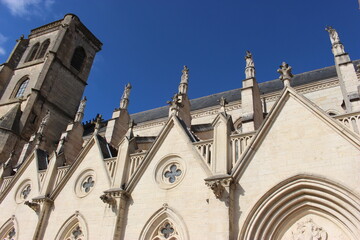 Auxonne, église Notre-Dame : vue latérale de biais (tour et statues) sous le ciel bleu