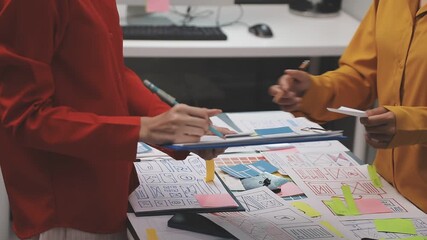 Group of young application developers analyzing uxui mobile app templates during a working meeting - Powered by Adobe