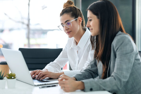 Businesswomen collaborating on startup project at office desk