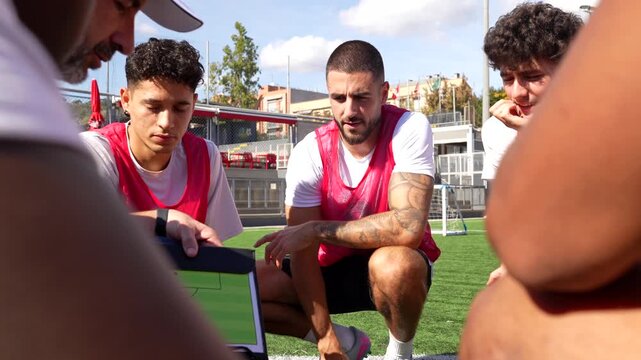 Soccer coach explaining strategy to players on field