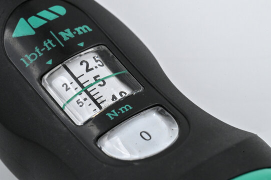 Close-up of a torque wrench scale showing Newton meter and pound-foot units, used for precise tightening measurement.