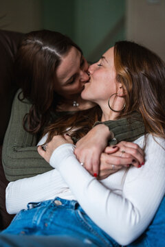 Couple embracing and kissing affectionately at home