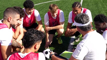 Soccer coach discussing game strategy with team during training - Powered by Adobe